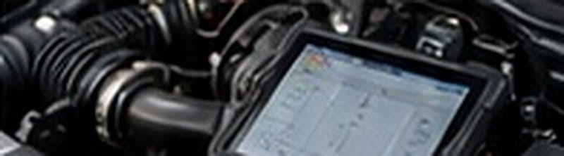 Diagnostic scan tool connected in an engine bay for a warning-light check